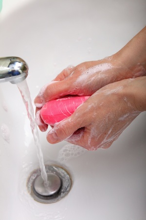 Woman wash red soapy hands in bathroom soapの写真素材