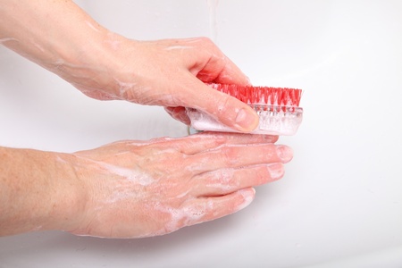Woman wash red soapy hands in bathroom soap nail brush person scrubbing nailsの写真素材