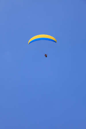 Paragliding. paraglider yellow over clear blue skyの写真素材