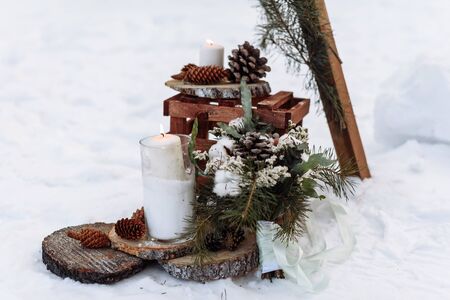 beautiful winter wedding decor with a burning candle and fir branches on a snow backgroundの写真素材