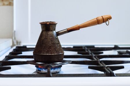ground coffee boils in a turk on a gas stoveの写真素材