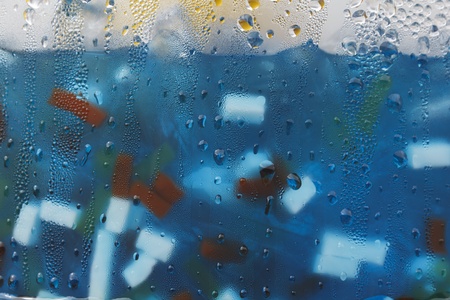 Background of blue sweet drink and piece of coconuts with water drops on glassの写真素材