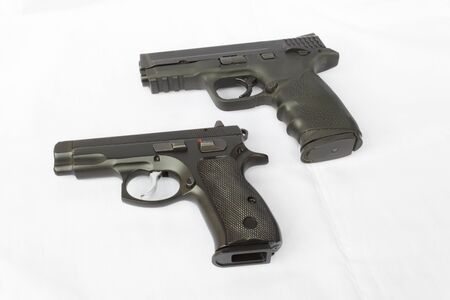 Black handguns on white fabric backgroundの写真素材