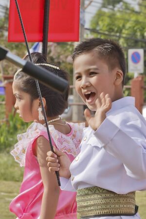 THAILAND - JULY 13: Thai students holding flag in Dokbual game school parade on July 13, 2012 in Suratthanee, Thailand.のeditorial素材