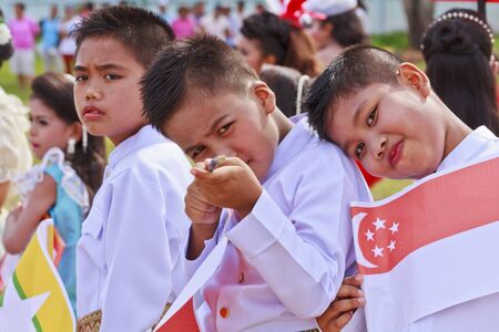 THAILAND - JULY 13: Thai boy students holding flag in Dokbual game school parade on July 13, 2012 in Suratthanee, Thailand.のeditorial素材