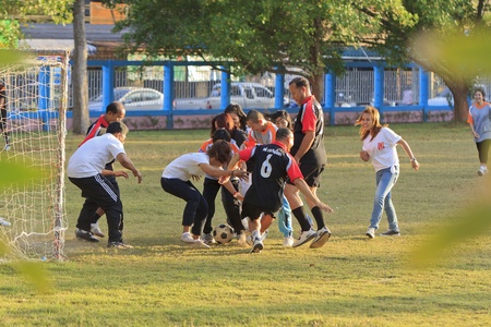 SURAT THANI, THAILAND - AUGUST 07, 2012 : Unidentified Thai women and men playing football game during celebrated Prince Rapee Day at Chiya Provincial Court on August 07, 2012 in Surat Thani, Thailand.のeditorial素材