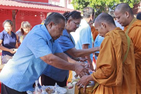 SURAT THANI, THAILAND - AUGUST 12, 2012 : Unidentified Thai peoples give food offerings to Buddhist monks during celebrated Mother's day as the birthday of Her Majesty Queen Sirikit at Chiya on August 12, 2012 in Surat Thani, Thailand.のeditorial素材