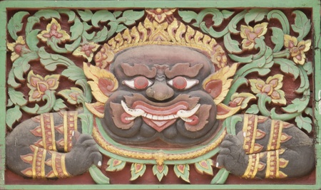 Antique art wood carving of celestial monster decoration on door of Thailand templeの写真素材