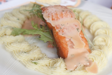 Grilled fish, salmon steak with a light sauce and cremeの写真素材