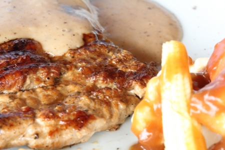 Fried pork chop with French fries and vegetables