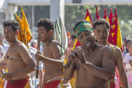 NAKHON SI THAMMARAT, THAILAND - OCTOBER 25: Taoist devotees participate in a street procession of the Nakhon Si Thammarat vegetarian festival on October 25, 2014 in Nakhon Si Thammarat province, Thailand. The festival was celebrated to make merit and saveのeditorial素材