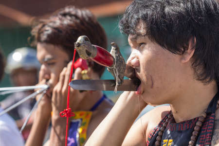 NAKHON SI THAMMARAT, THAILAND - OCTOBER 25: Taoist devotees participate in a street procession of the Nakhon Si Thammarat vegetarian festival on October 25, 2014 in Nakhon Si Thammarat province, Thailand. The festival was celebrated to make merit and saveのeditorial素材