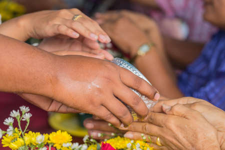 Pour water on the hands of revered elders and gives blessing in Songkran festivalの写真素材