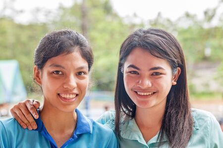 Portrait of two women outdoors hugging and smilingの写真素材
