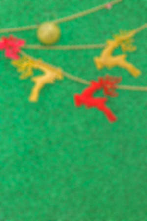 Defocused green background with golden Christmas ball and deerの写真素材