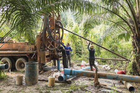 NAKHON SI THAMMARAT, THAILAND - DECEMBER 7: Men working a drilling rig to a water well for crop irrigation on December 7, 2015 in Nakhon Si Thammarat, Thailand.のeditorial素材