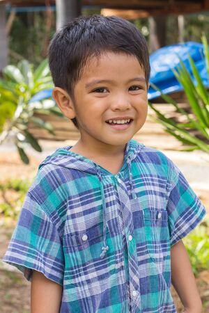 Cute outdoor portrait of happy smiling Asian Thai little boyの写真素材