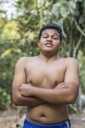 Portrait of a happy young Asian man standing crossing his arms and smilingの写真素材