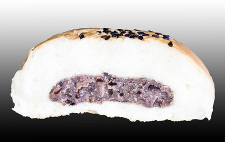 Bun with sesame seeds and black bean isolated on black background cutout with clipping pathの写真素材