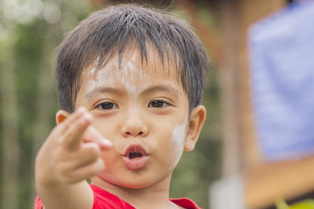 Asian Thai little boy making gun gesture with fingerの写真素材