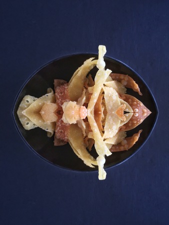Crispy deep fried wonton in bowl on black backgroundの写真素材