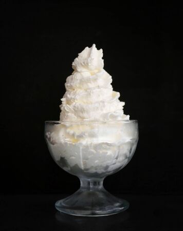 Whipped cream in glass on dark background