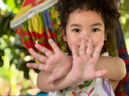 Portrait of a cute little girl having fun in a hammockの写真素材