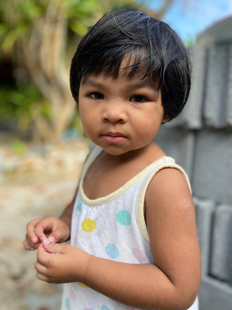Portrait of a cute Asian baby girl in the gardenの写真素材