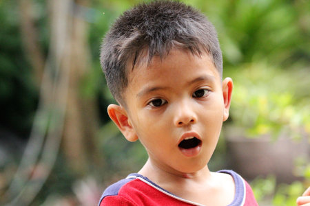 Surprised asian boy looking in the gardenの写真素材