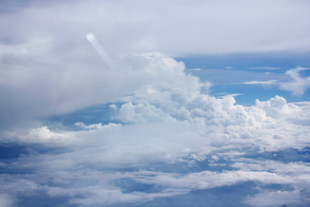 Clouds and sky as seen through window of an aircraft during flight