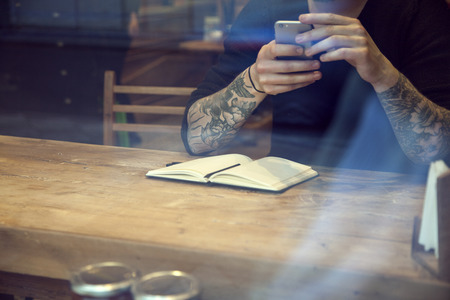 Portrait of handsome white hipster man work in cafe close-upの写真素材