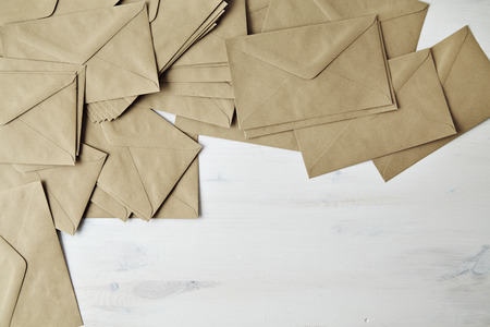 Mess of brown kraft paper post envelope on wood tableの写真素材