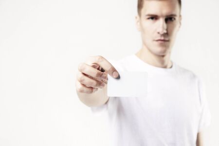 Portrait of attractive man holding blank business card, empty space for layout, with white backgroundの写真素材