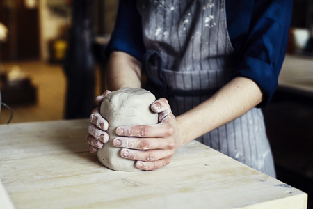 Woman hands close-up, forming crude clay in a potter's workshop studio. Craft-workの写真素材