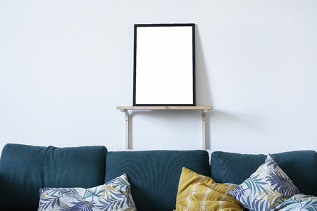 Poster in black frame in nordic stylish modern interior on white wall, green sofa in living room. Empty space for design layout.の写真素材