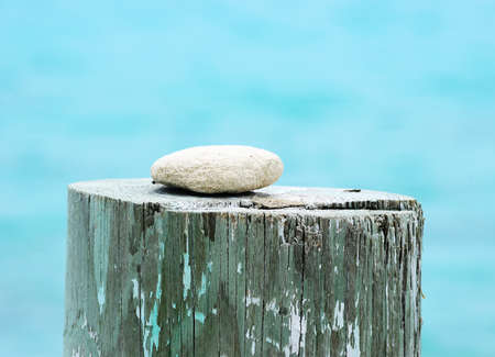 White rock on a pier with aqua blue water in the background.の写真素材
