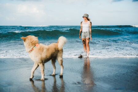 Tattooed woman walking at beachの写真素材
