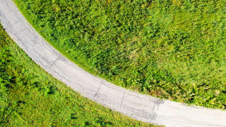 Aerial view of a road in italian countryside between fields and meadows