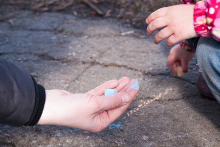 Hand with chalk writing on blackboard - education backgroundの写真素材