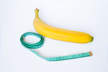 The meter measures the length of a banana on a white backgroundの写真素材