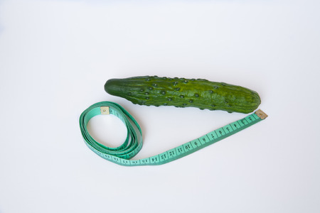 cucumber with tape measure isolated on white backgroundの写真素材
