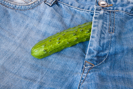 A young man with a cucumber stuffed down his pantsの写真素材