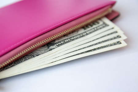 Money in female red leather purse isolated on white background