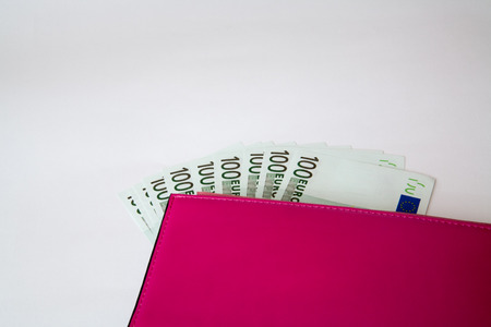 Money in female red leather purse isolated on white backgroundの写真素材
