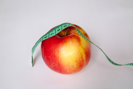 Apple and ruler are isolated on a white backgroundの写真素材
