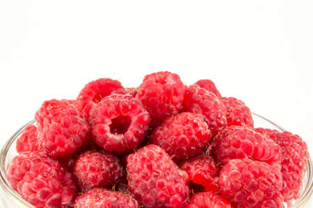 tasty and juicy raspberries in a glass plate