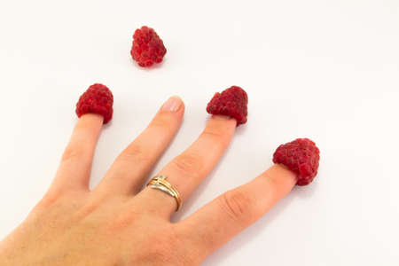 healthy eating dieting vegetarian food and people concept close up of woman hands holding raspberries at homeの写真素材