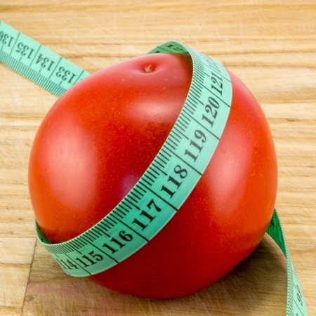 A diet using red tomatoes concept using centimeter to measure the caloriesの写真素材