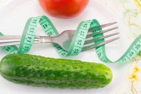 cucumber with tape measure isolated on white backgroundの写真素材