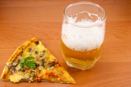 delicious pizza and beer foam in a glassの写真素材